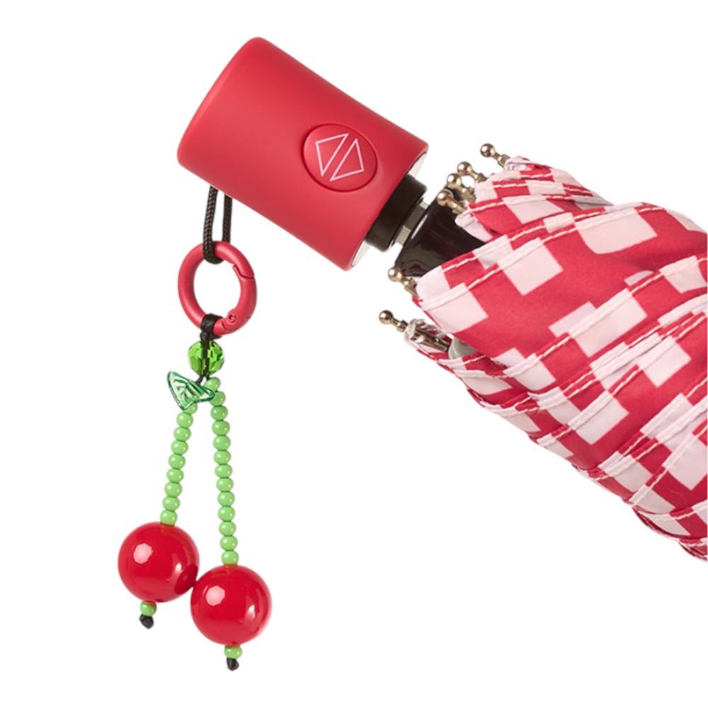 Detalle del tejido estampado y el original colgante de cerezas del paraguas automático Bisetti Gridix para mujer.