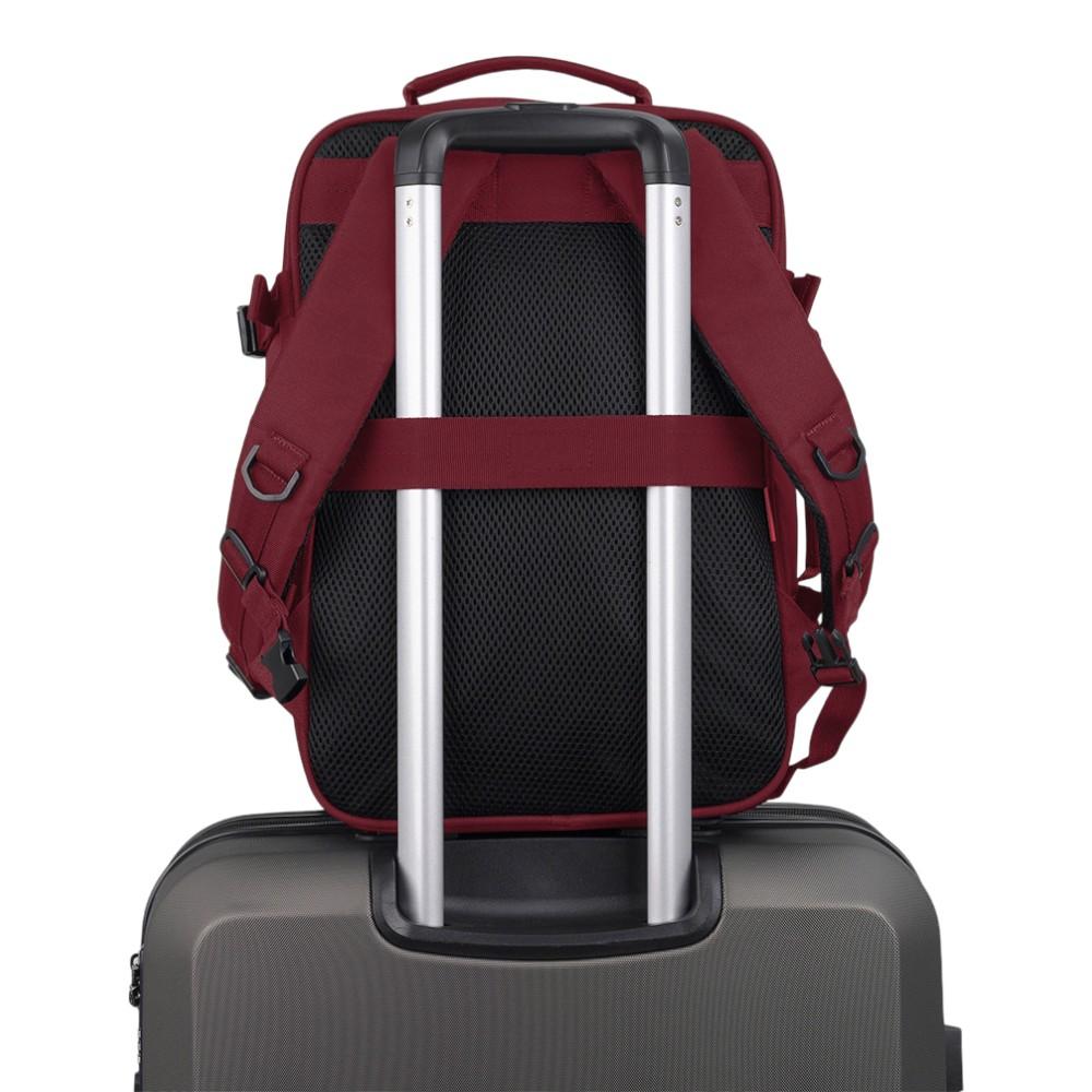Vista trasera de la mochila Gabol Week burdeos colocada sobre una maleta mediante su cinta de acople para el asa telescópica.