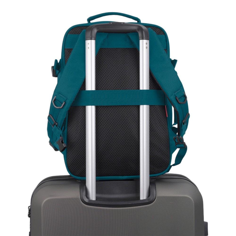 Vista trasera de la mochila Gabol Week turquesa colocada sobre una maleta gracias a su cinta para acoplarla al asa telescópica.
