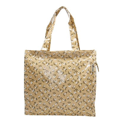  Vista frontal de la bolsa destacando el patrón de flores y las asas reforzadas