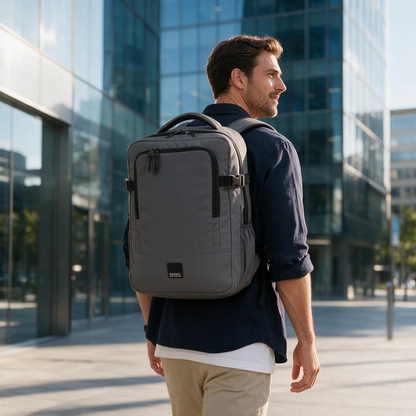 Hombre caminando con mochila gris Gabol Vancouver de Luisipo, ideal para viajes y portátil, en entorno urbano.